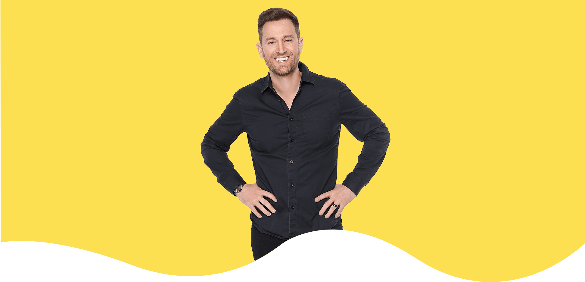 Smiling man in black shirt against yellow background.