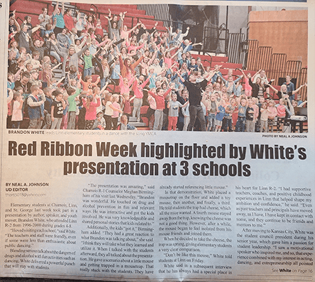 A large group of people celebrating with raised hands on a stage.