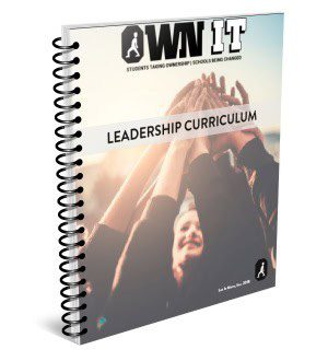 A spiral-bound leadership curriculum workbook with a person raising hands.