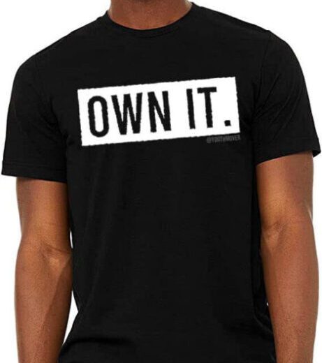 Black t-shirt with bold white text 'OWN IT.' on the front.