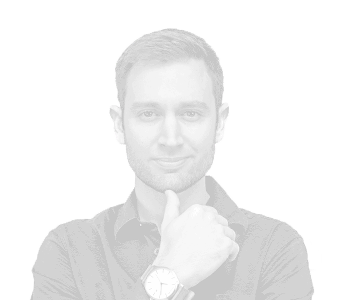 A man posing thoughtfully with his hand on his chin, dressed in a shirt and blazer.