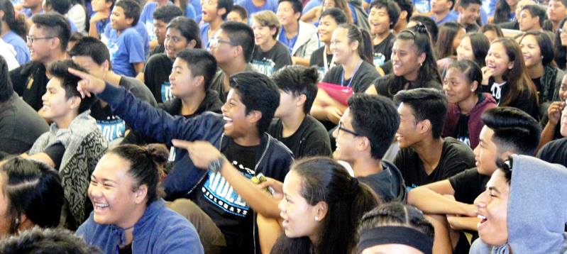 A crowd of people engaged and pointing in one direction.