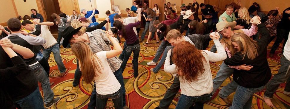 People enjoying a lively dance session in a decorated indoor venue.
