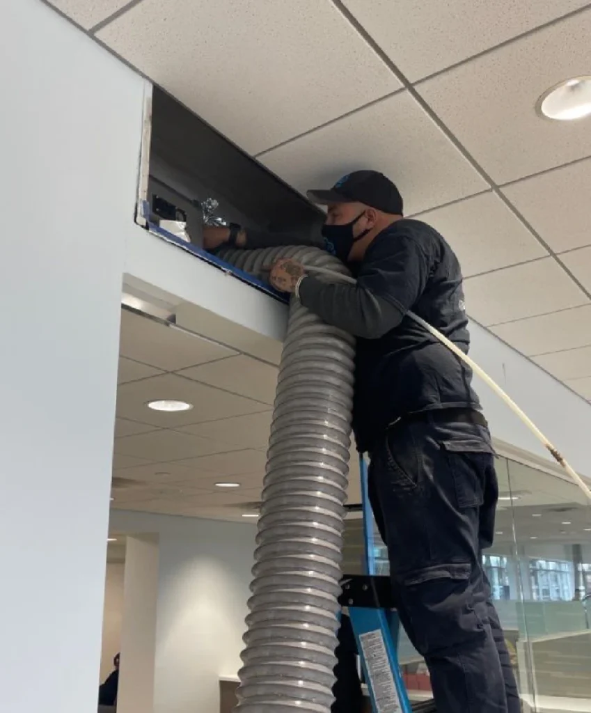 technician cleaning air duct of a commercial building